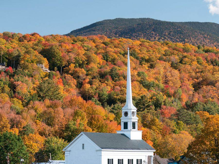 Igreja branca típica da Nova Inglaterra em meio à folhagem de outono nos Berkshires